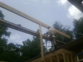 Carpenter setting a ridge beam over a new addition frame — Ice Dam Removal by Roofing Brothers in Palermo